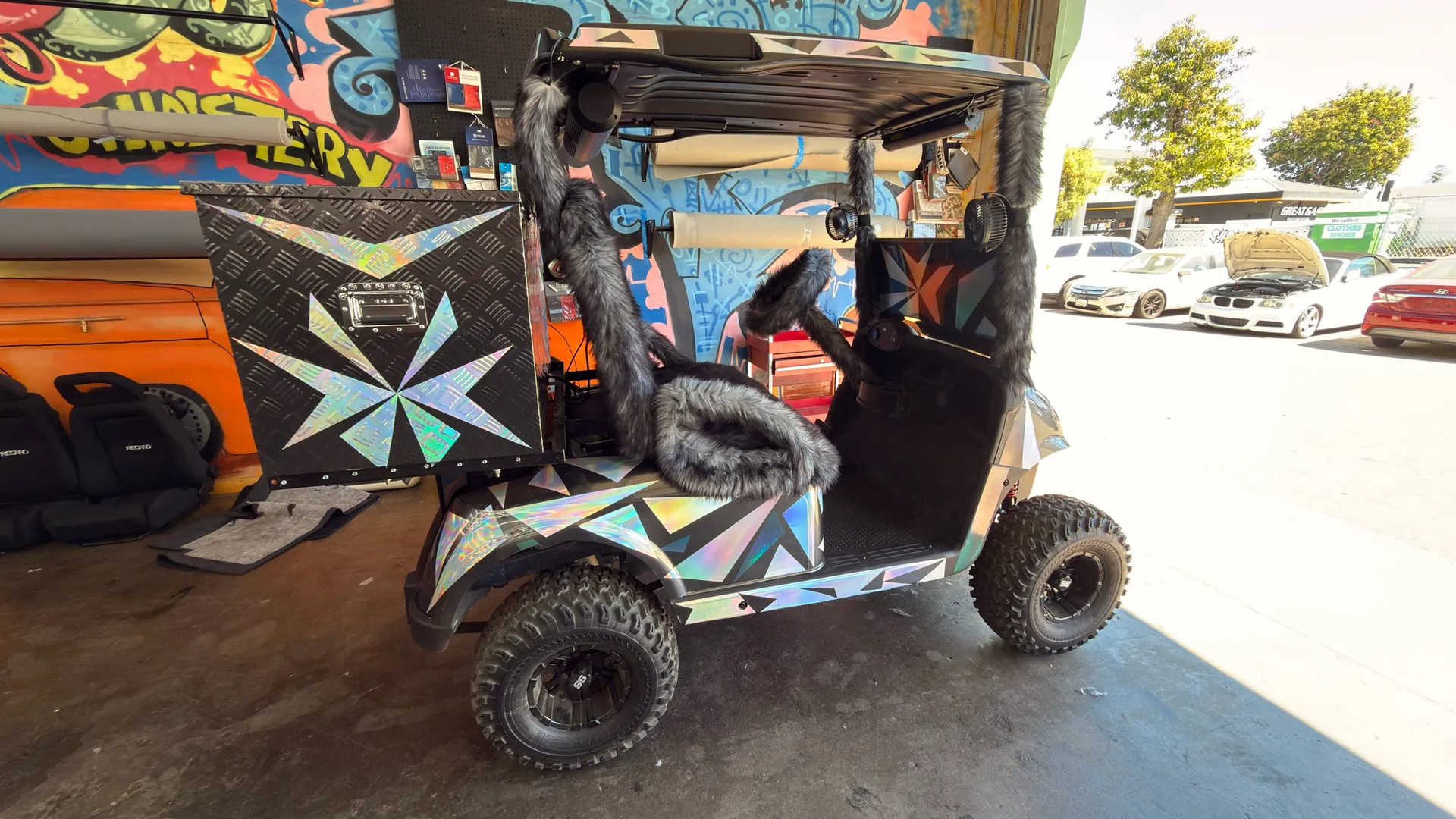 The completed customer golf cart with gray upholstery and reflective geometric body graphics at ABC Auto Upholstery.